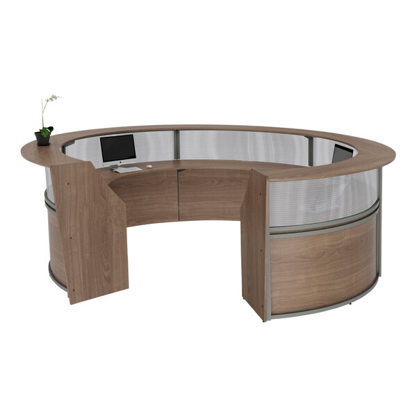 A Correll walnut laminate curved reception desk with a computer on it.