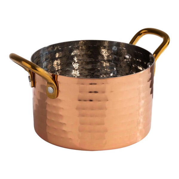 An APS Mumbai round hammered copper serving pot with two handles.