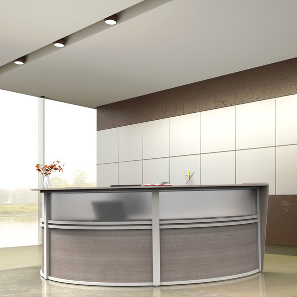 A Correll ash laminate U-shaped reception desk with a curved glass counter.