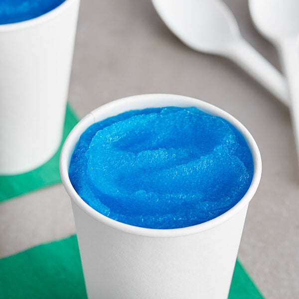 A white cup filled with blue I. Rice Rocket Pop water ice.