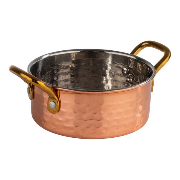 An APS Mumbai round hammered copper serving pot with a handle.