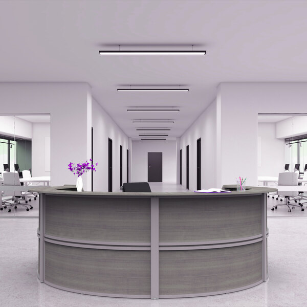 A white 4 panel curved U-shape reception counter with a book on top in a modern office.