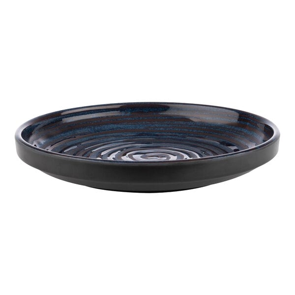 A blue APS Loops melamine plate with a swirl pattern on a table outdoors.