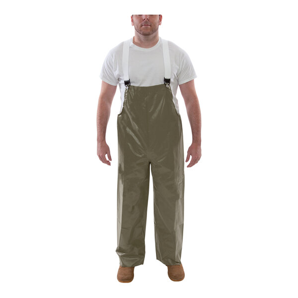 A man wearing Tingley Magnaprene olive drab green overalls.