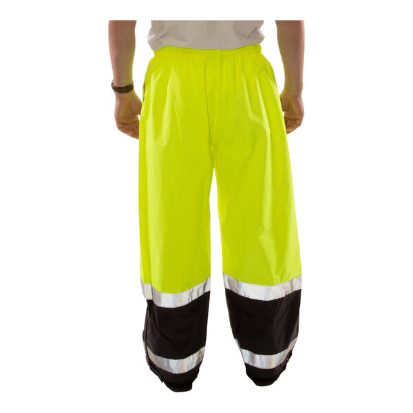 A person wearing Tingley hi-vis yellow pants with black cuffs.