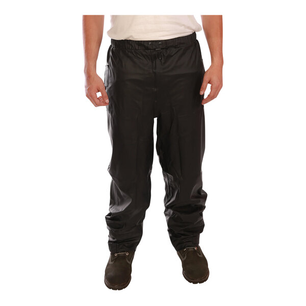 A man wearing Tingley black rain pants.