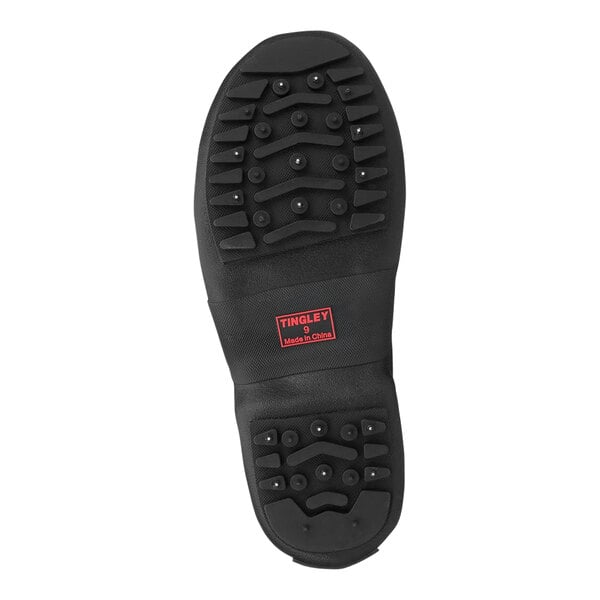A close-up of the black Tingley Winter-Tuff ice traction overshoe with red rubber soles and a red logo.