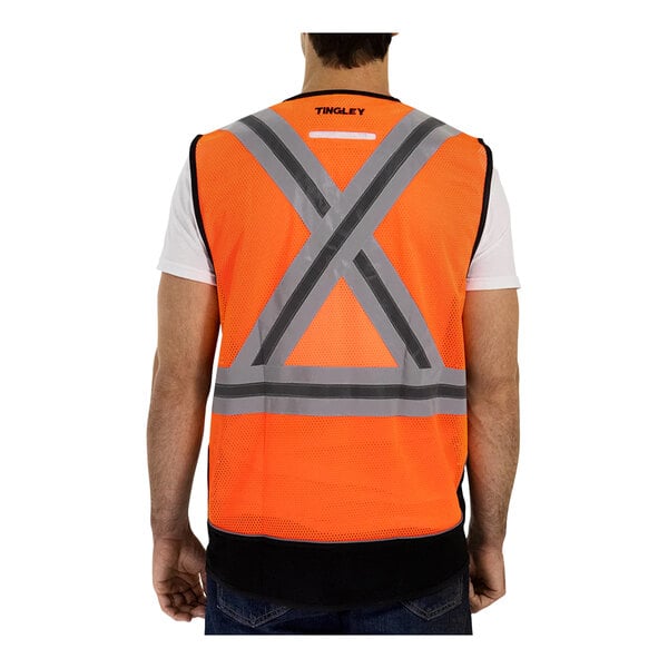 A man wearing a Tingley hi-vis orange safety vest with an X on the back.