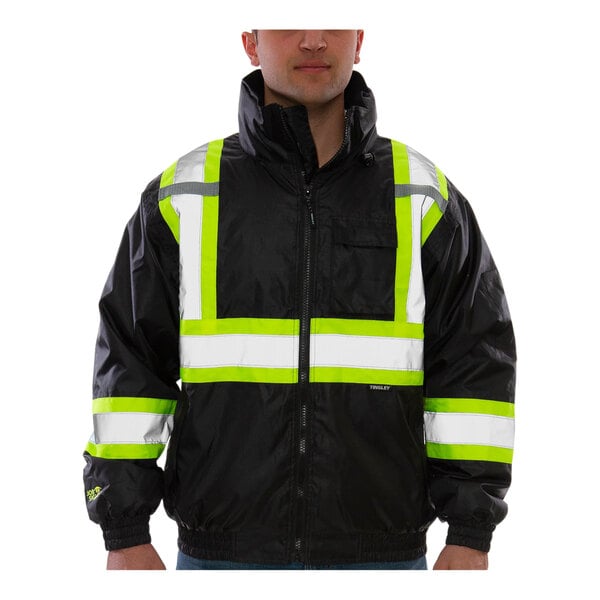A man wearing a black Tingley Bomber II jacket with yellow and white reflective stripes.