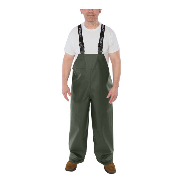 A man wearing green Tingley Weather-Tuff rain overalls with suspenders.