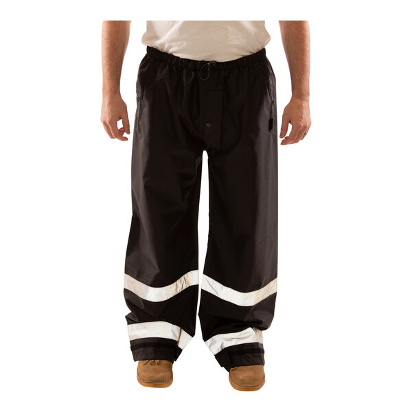 A man wearing Tingley Icon black pants with reflective tape on the legs.