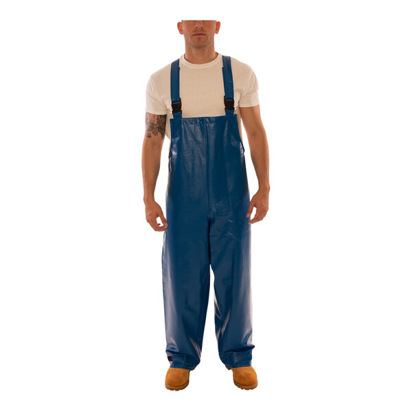 A man wearing Tingley blue overalls with blue straps.
