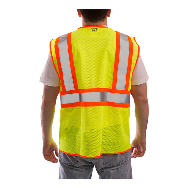 A man wearing a Tingley Job Sight yellow safety vest with reflective stripes.