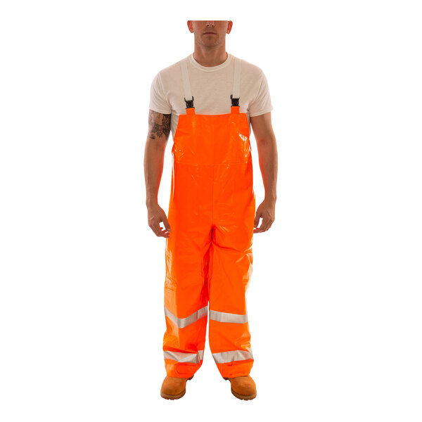 A person wearing Tingley orange rain overalls with reflective stripes.