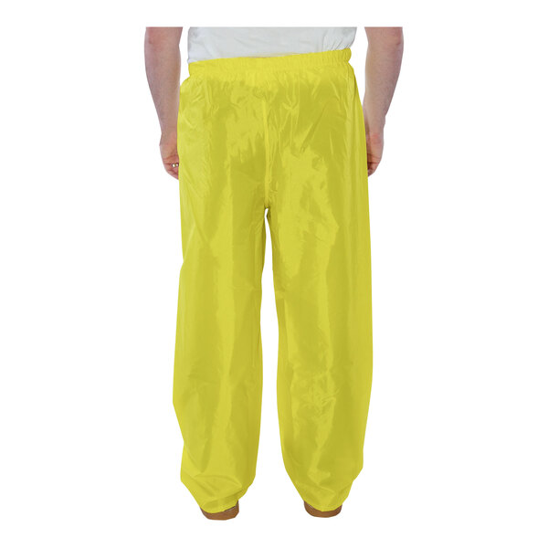 A person wearing yellow Tingley Eagle rainsuit pants.