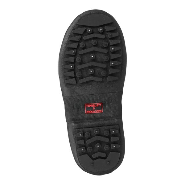 A black Tingley rubber overshoe with red soles.