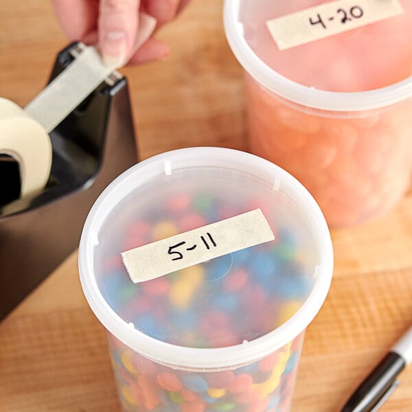 A plastic container of candy with Lavex General Purpose Masking Tape on it.