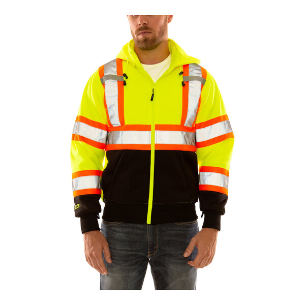 A man wearing a yellow and black Tingley Job Sight zip-up sweatshirt with reflective tape and a hood.