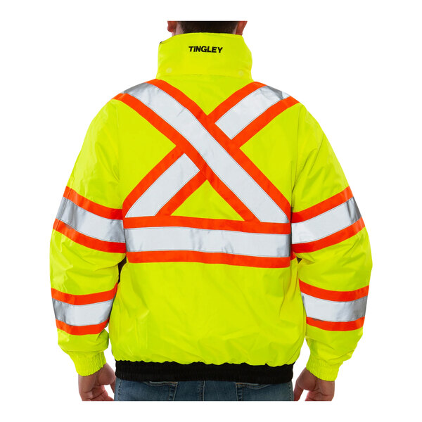 A person wearing a Tingley yellow safety jacket with black and reflective stripes.