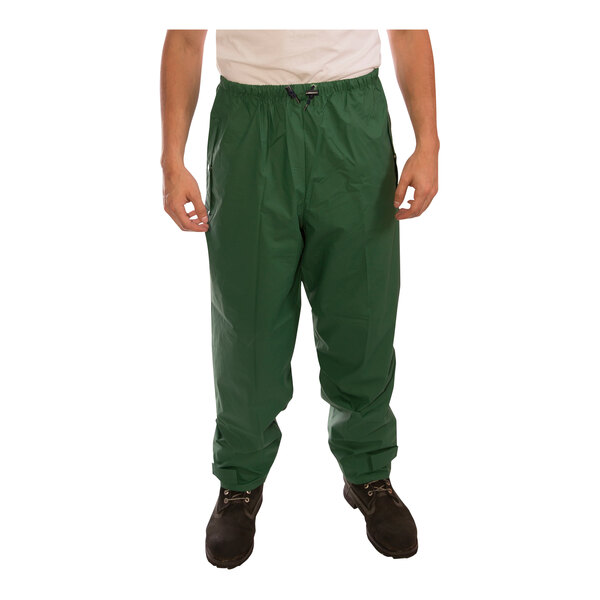 A man wearing a green Tingley Storm-Champ rainsuit with pants.