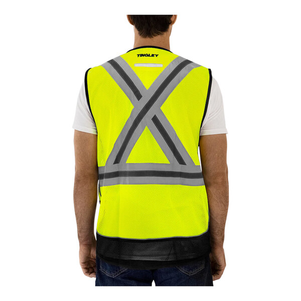 A man wearing a Tingley hi-vis yellow safety vest with X-back reflective tape.