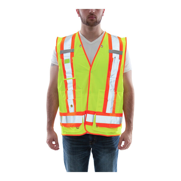 A man wearing a Tingley Hi-Vis lime yellow safety vest with reflective X on the back.