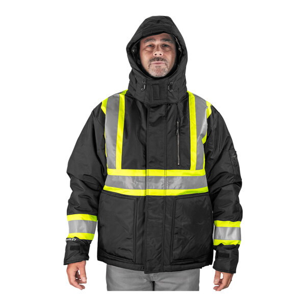 A man wearing a Tingley black insulated jacket with reflective accents.
