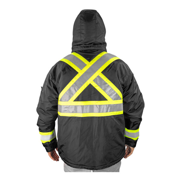 A person wearing a Tingley black jacket with yellow reflective stripes.