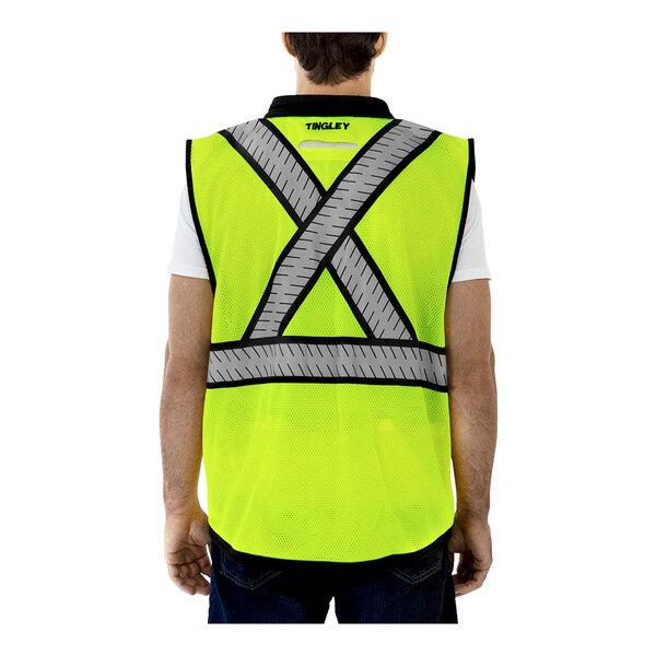 A man wearing a Tingley yellow safety vest with an X on the back.