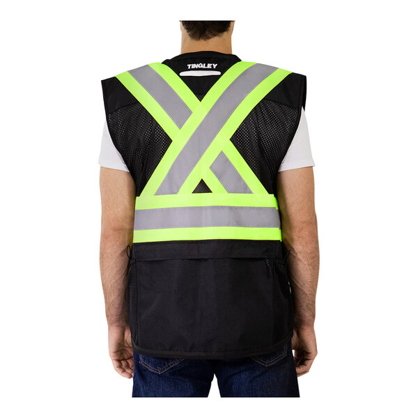 A man wearing a Tingley hi-vis safety vest with X-back reflective tape.