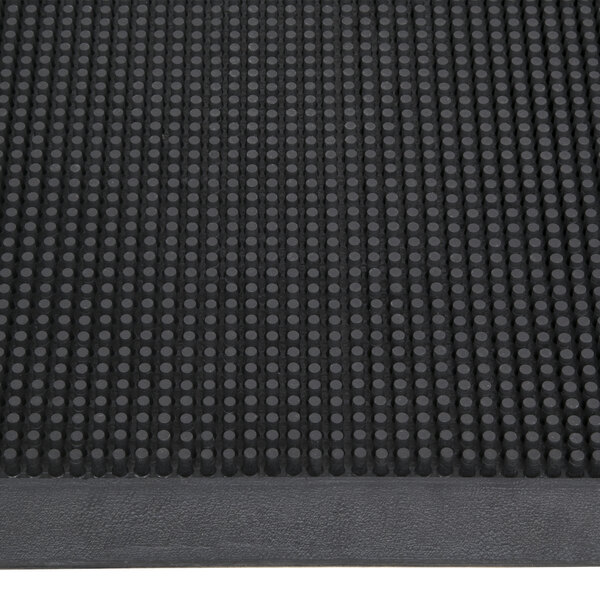 A close-up of a black rubber Cactus Mat with holes in it.