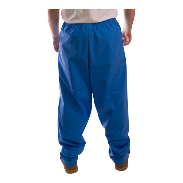 A person wearing a Tingley blue rainsuit with blue pants.