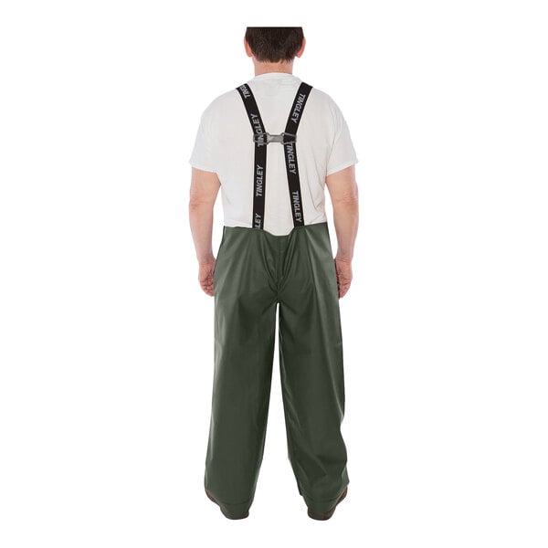 A man wearing Tingley green Weather-Tuff rain overalls and suspenders over a white shirt.