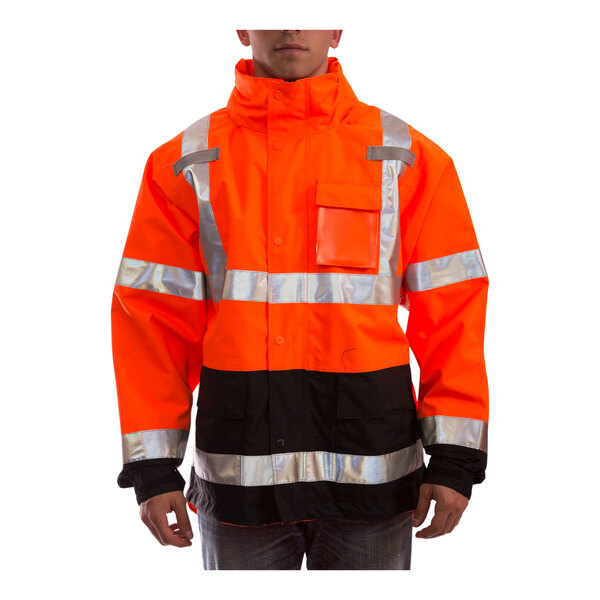 A person wearing a Tingley orange and black safety jacket with reflective stripes.