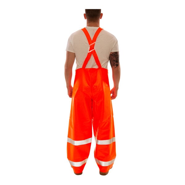 A person wearing Tingley orange overalls with reflective stripes.