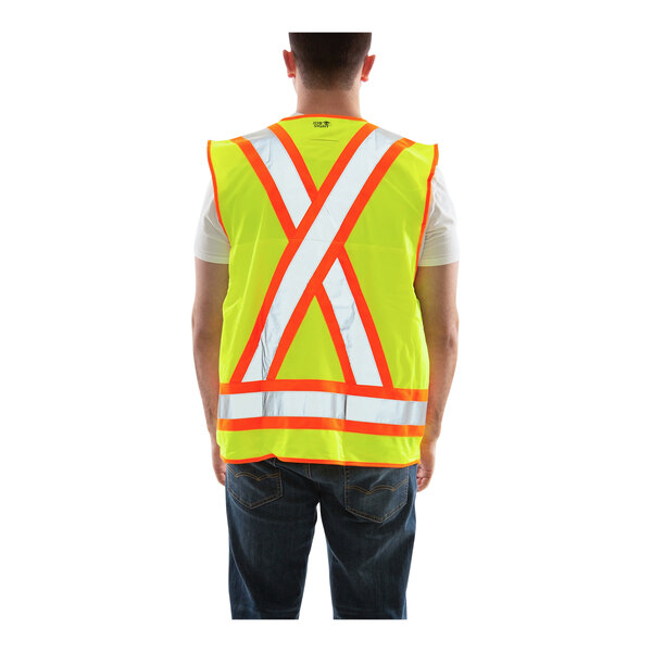 A man wearing a Tingley yellow safety vest with X-back reflective tape over a white shirt.
