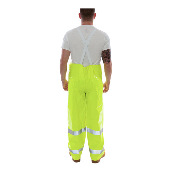 A man wearing Tingley Hi-Vis lime yellow rain overalls.