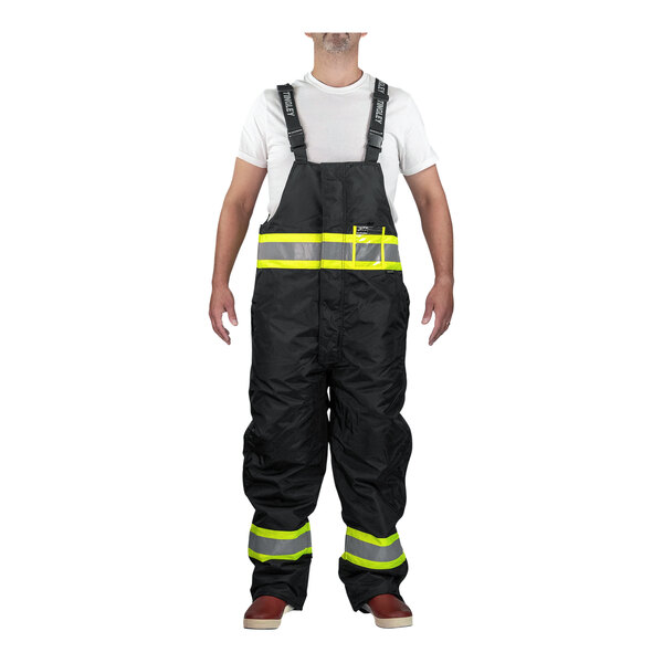 A man wearing Tingley black insulated overalls with reflective stripes over a white shirt.
