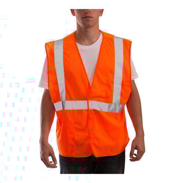 A person wearing a Tingley Job Sight hi-vis orange safety vest with reflective stripes.