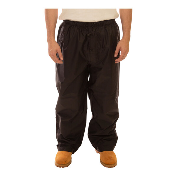 A person wearing Tingley black pants and a white shirt.