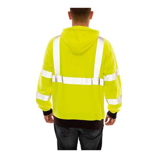 A person wearing a Tingley lime yellow flame-resistant zip-up sweatshirt.