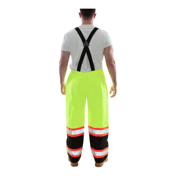 A man wearing Tingley lime yellow safety overalls with black cuffs.