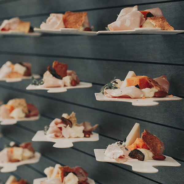 VerTerra small square compostable balsa wood cheese boards on a table in a catering event.