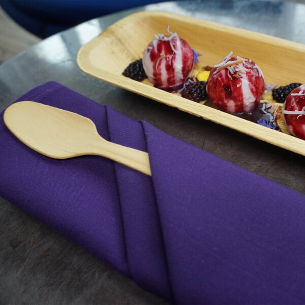 A VerTerra wooden spoon next to a bowl of ice cream.
