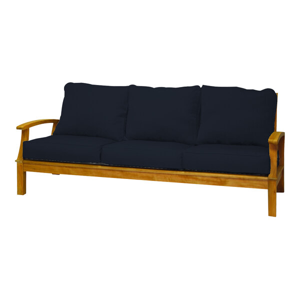 A Three Birds Casual Monterey wooden sofa with navy cushions.