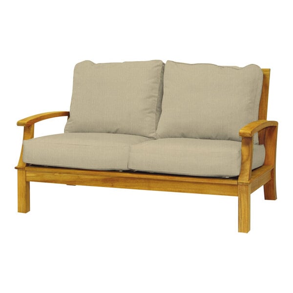 A Three Birds Casual Monterey wooden loveseat with beige cushions.