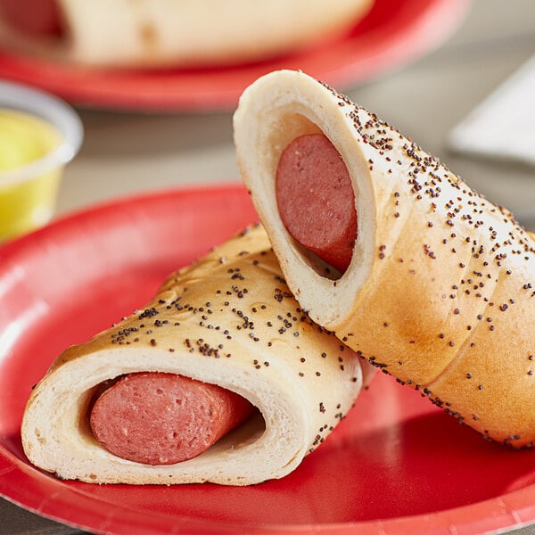 Two Vienna Beef bagel dogs in rolls on a red plate.