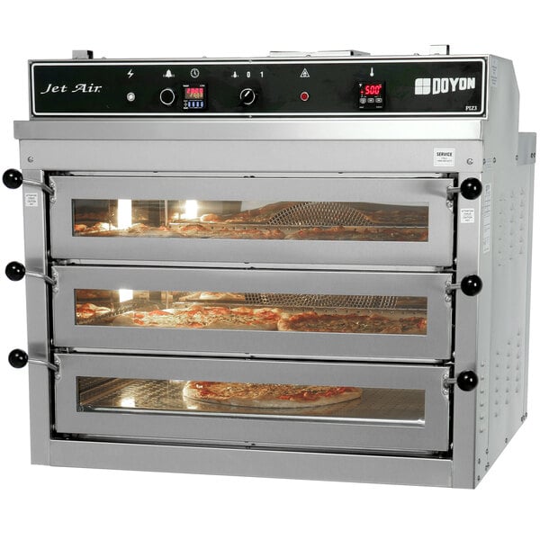 A large Doyon natural gas pizza oven with three trays of pizza inside.