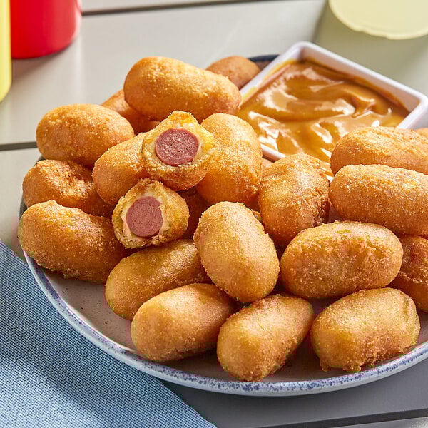 A plate of State Fair Classic Mini Corn Dogs with sauce.