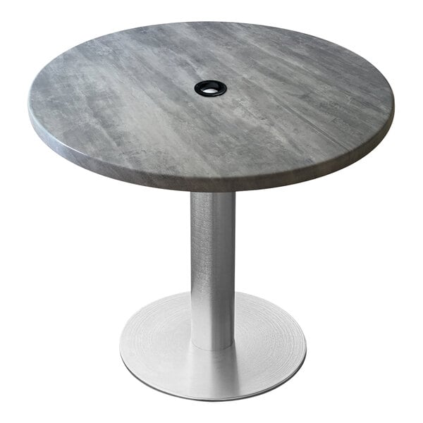 A round grey Holland Bar Stool table with a brushed aluminum base and an umbrella hole.